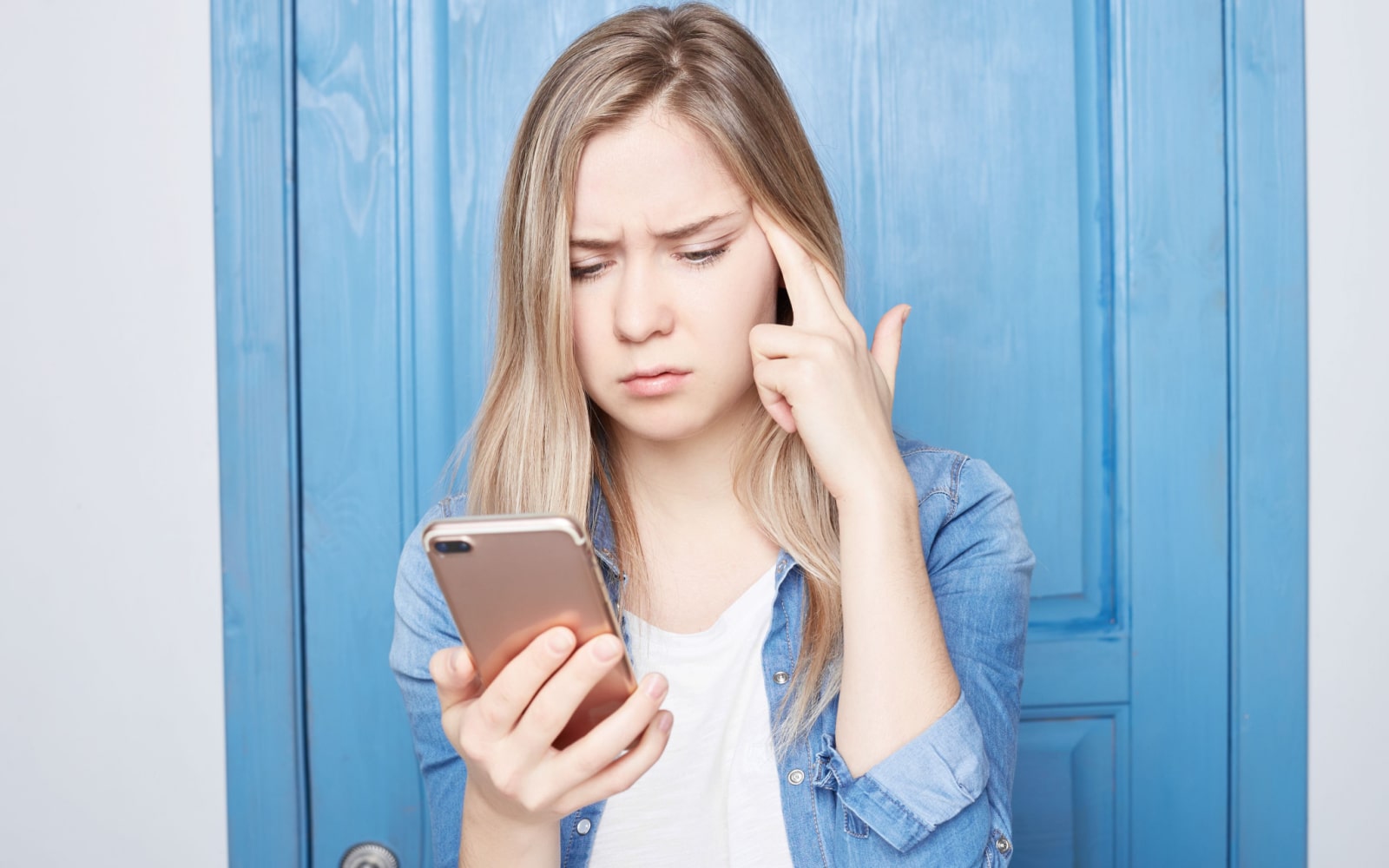 Woman Frowning at Smart Phone Screen